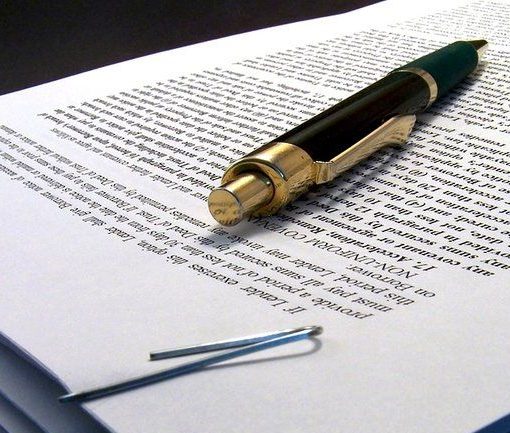 A person grasping their ankle while sitting on a floor.